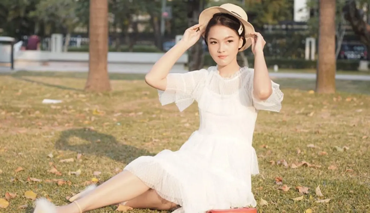 Blouse putih yang dipadukan dengan topi dan jepit rambut, membuat gaya berlibur wanita 27 tahun ini rapi namun tetap santai. Manis banget ya! (Liputan6.com/IG/@anariana27)