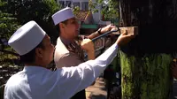 Jajaran Polresta Probolinggo, Jawa Timur dan santri Ponpes An-Nur menggelar aksi cabut paku di pohon-pohon sepanjang jalan protokol. (Liputan6.com/Dian Kurniawan)
