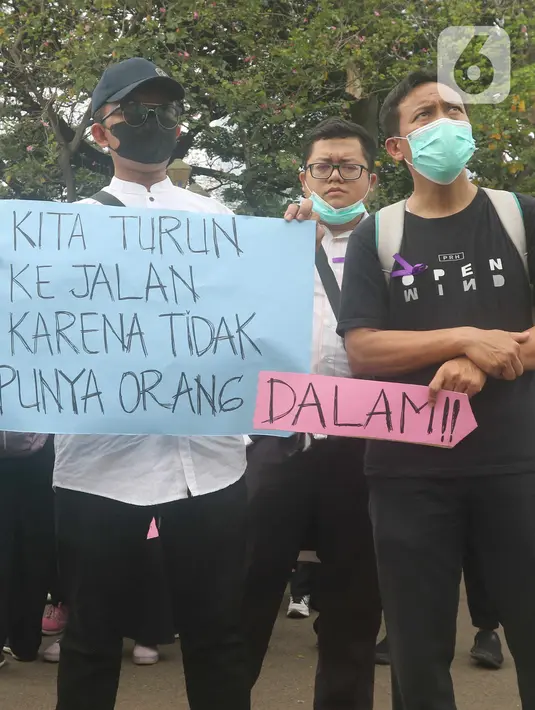 Massa dari Forum Komunikasi Nakes dan Non-Nakes Indonesia (FKHN Indonesia) membentangkan poster saat menggelar aksi di kawasan Patung Kuda, Jakarta Pusat, Kamis (22/9/2022). Sejumlah petugas gabungan berjaga di sekitar lokasi aksi dan awat berduri serta road barrier juga telah disiagakan. (Liputan6.com/Herman Zakharia)