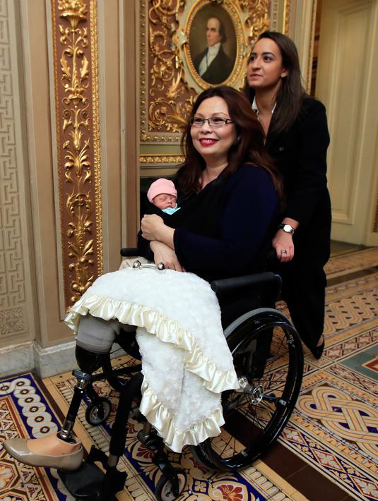 Senator Illinois, Tammy Duckworth membawa bayinya meninggalkan ruang kongres Gedung Capitol Hill, Washington DC, Kamis (19/4). Pekan lalu, Duckworth menjadi senator AS pertama yang melahirkan, saat masih aktif bekerja di Kongres. (AP/Manuel Balce Ceneta)