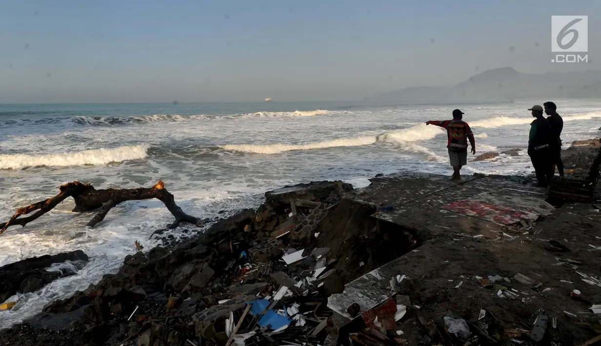 Warga melihat ombak pasang yang telah menghancurkan puluhan rumah di Karanghawu, Pelabuhan Ratu, Sukabumi, Minggu (29/7). Gelombang pasang juga menyebabkan abrasi karena tanggul penahan ombak yang dibuat warga rusak berat. (Merdeka.com/Arie Basuki)