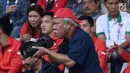 Menteri PUPR, Basuki Hadimuljonobersiap mengabadikan momen saat laga semifinal bulu tangkis beregu putra Asian Games 2018, Indonesia melawan Jepang di Jakarta, Selasa (21/8). Indonesia unggul dan lolos ke final. (Liputan6.com/Helmi Fithriansyah)
