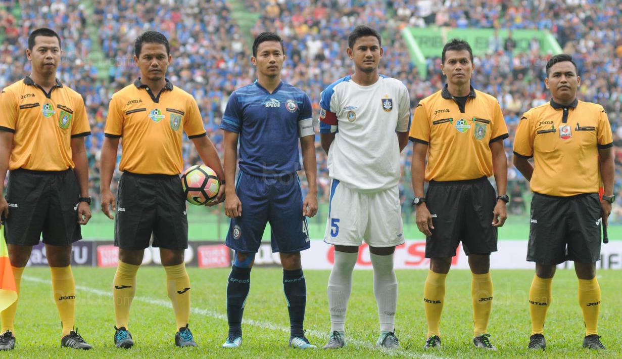 Kapten baru Arema FC, Dendi Santoso, foto bersama kapten PSIS dan wasit sebelum laga uji coba di Stadion Gajayana, Malang, Kamis (4/1/2018). Arema FC menang 5-3 atas PSIS. (Bola.com/Iwan Setiawan)