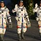 (kiri-kanan) Astronaut China Tang Hongbo, Nie Haisheng, dan Liu Boming melambai saat bersiap untuk lepas landas dari Pusat Peluncuran Satelit Jiuquan, China, Kamis (17/6/2021). Para astronaut menuju Tianhe, modul awal stasiun ruang angkasa Tiangong (Istana Surgawi) China. (AP Photo/Ng Han Guan)