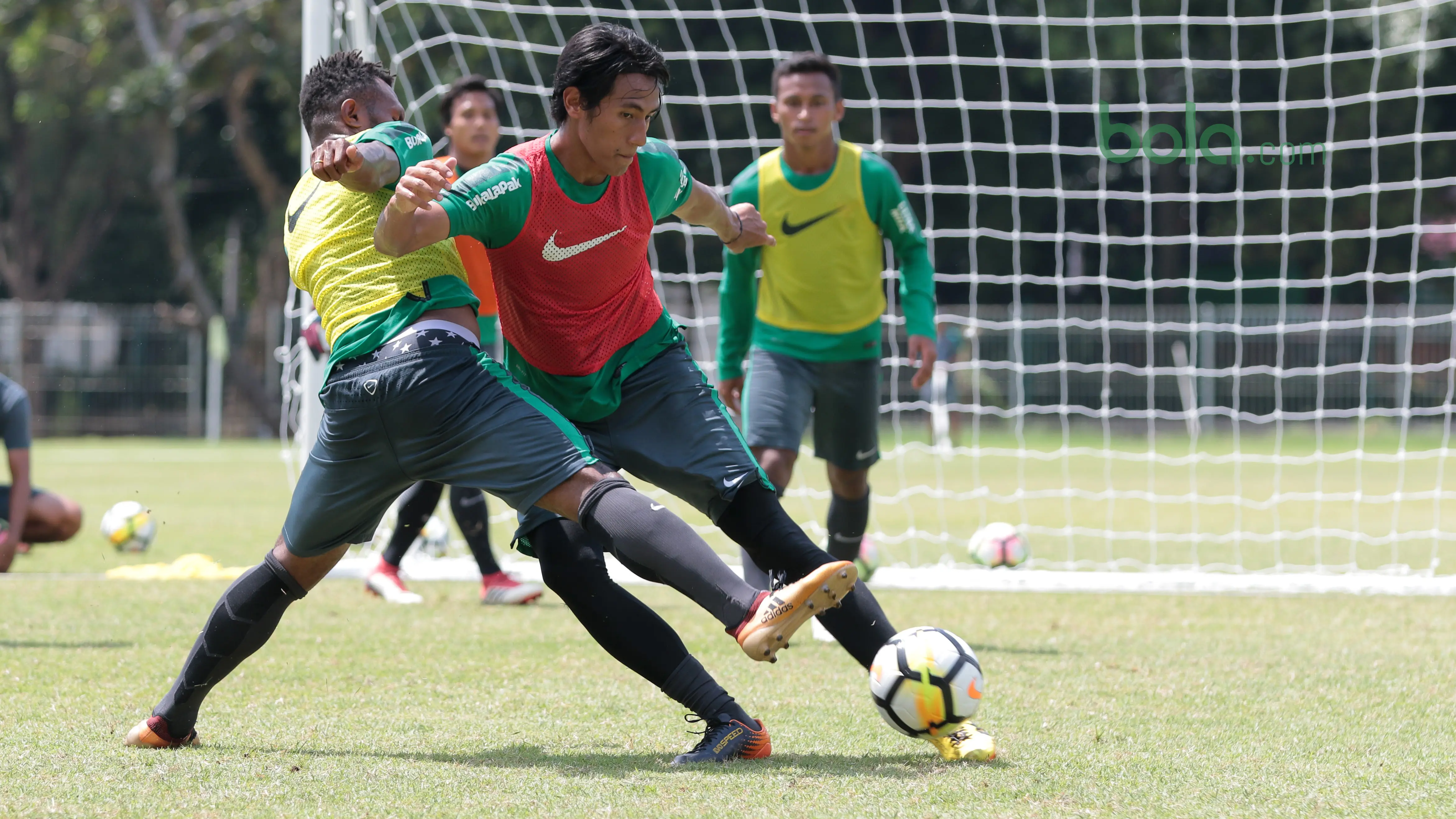 Pemain Timnas Indonesia U-23, Hanif Sjahbandi berebut bola dengan Nelson Alom pada sesi latihan di Lapangan A,B,C, Senayan, Jakarta (21/2/2018). Latihan ini merupakan persiapan Asian Games 2018. (Bola.com/Nick Hanoatubun)