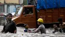 Anak-anak bermain air di jalanan yang banjir akibat hujan lebat di Mumbai, India, Selasa (29/8). Badan Bantuan Internasional menyebut meski banjir telah menjadi bencana langganan, musibah tahun ini merupakan yang paling buruk. (AP Photo/Rajanish Kakade)