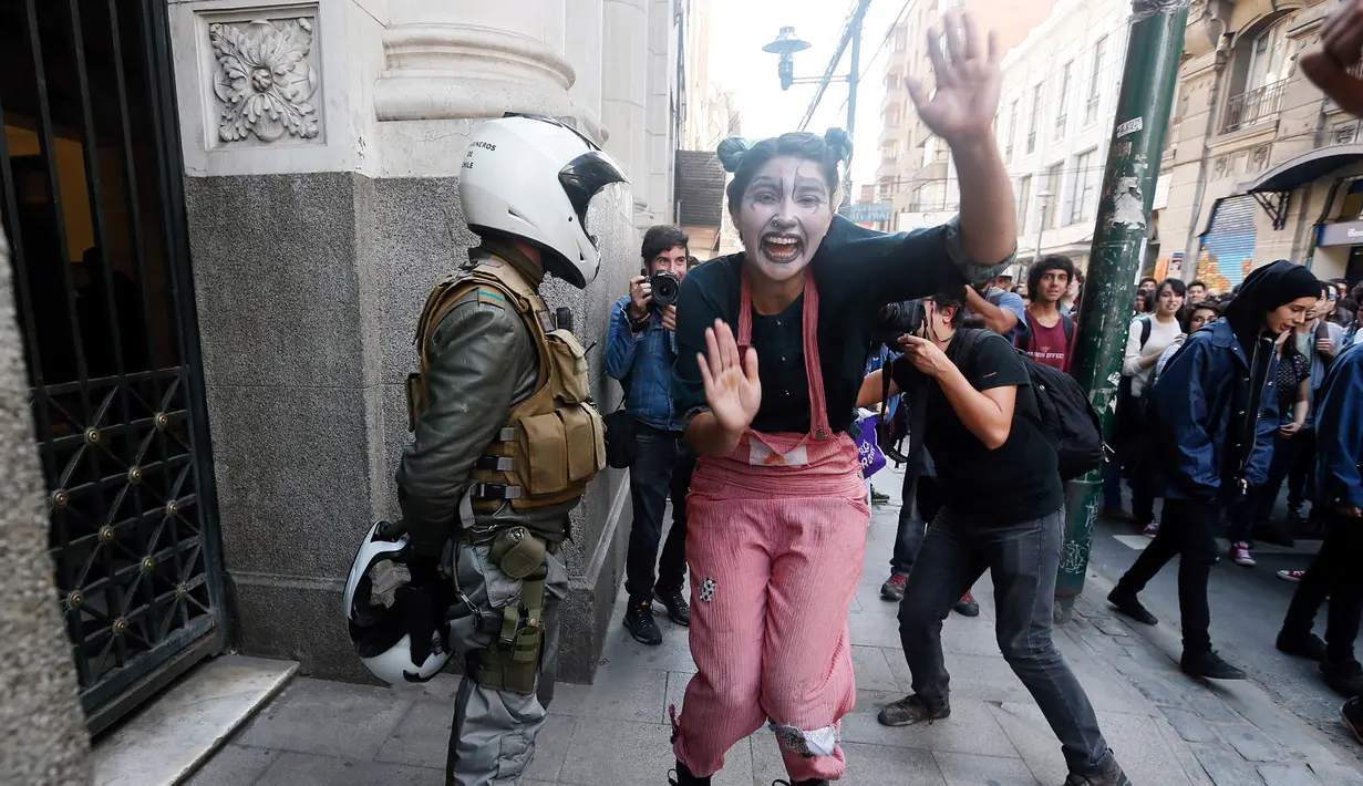 Seorang pelajar mengecat mukanya saat melakukan demonstasi di Santiago , Chile , 21 April 2016. Sejumlah pelajar nekat melempari polisi dengan batu dan bom rakitan. (REUTERS / Clemente Villavicencio)
