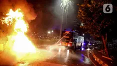 Mobil polisi menyemprotkan air untuk memadamkan api usai demonstrasi yang berujung anarkis di kawasan Bundaran HI, Jakarta, Kamis (8/10/2020). Massa membakar sejumlah barang saat demonstrasi menolak pengesahan UU Cipta Kerja. (Liputan6.com/Faizal Fanani)