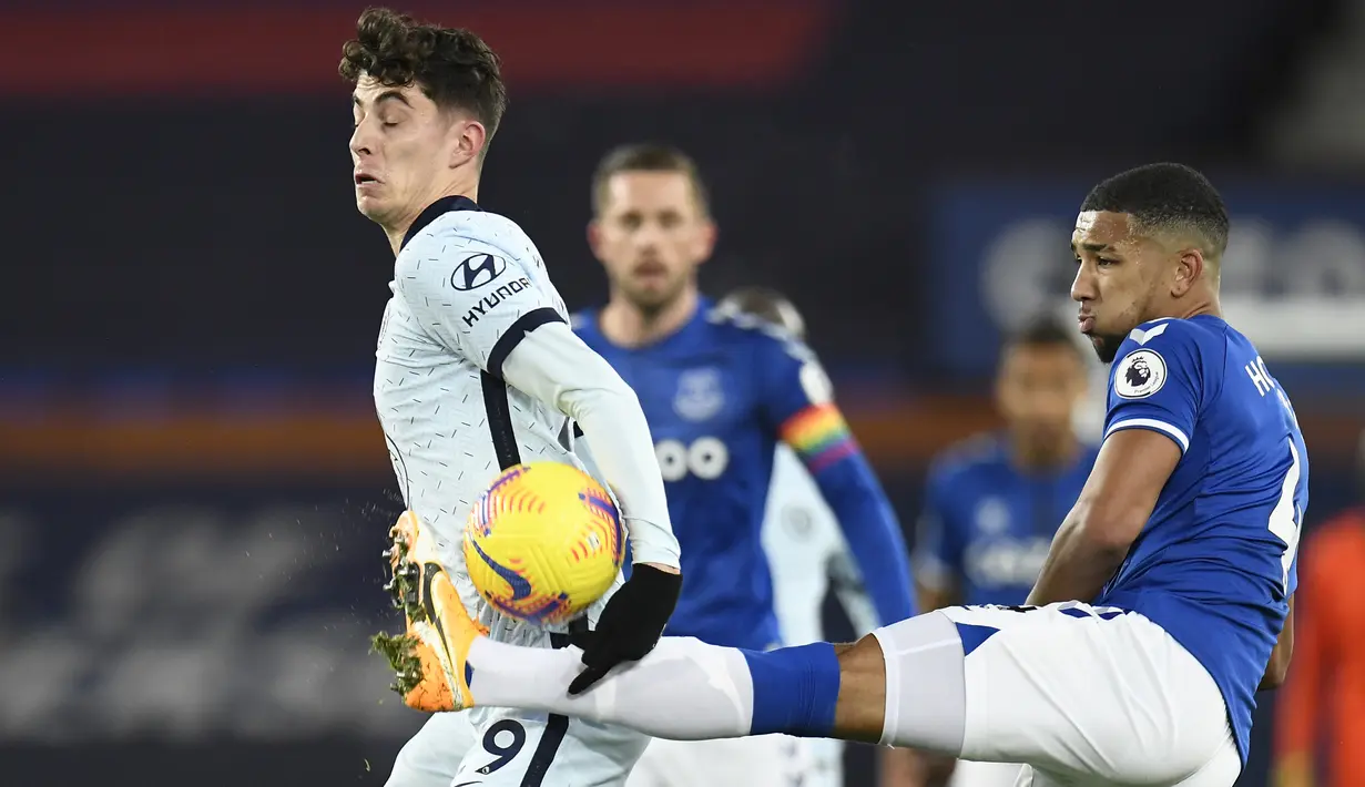 Bek Everton, Mason Holgate (kanan), berebut bola dengan gelandang Chelsea, Kai Havertz, dalam laga lanjutan Liga Inggris 2020/21 pekan ke-12 di Goodison Park Stadium, Sabtu (12/12/2020). Everton menang 1-0 atas Chelsea. (AFP/Peter Powell/Pool)