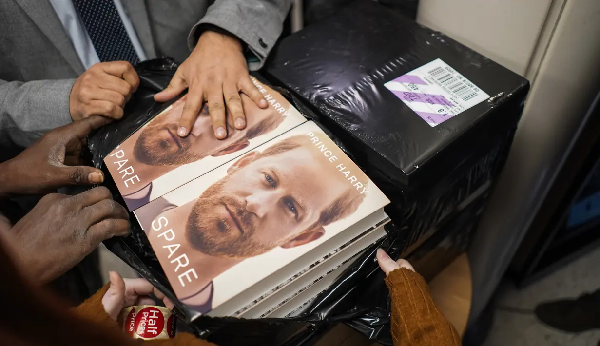 Buku baru Pangeran Harry berjudul "Spare" dipegang oleh anggota staf toko buku saat pembukaan tengah malam di London, Selasa (10/1/2023). Memoar baru Harry yang memamerkan jiwa, "Spare," telah menghasilkan berita utama yang membara bahkan sebelum dirilis. (AP/Alberto Pezzali)