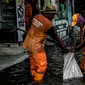 Petugas PPSU membersihkan sampah saat terjadi banjir rob di Pelabuhan Kali Adem, Muara Angke, Jakarta, Selasa (9/11/2021). Walau terendam banjir rob, petugas PPSU tetap sigap bersihkan sampah yang mengambang terbawa air laut. (Liputan6.com/Faizal Fanani)