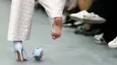 Sepatu seorang model terlepas saat memperagakan busana rancangan Emilio De la Morena pada London Fashion Week 2017 di Inggris, Selasa (20/9).  Meski sepatunya terlepas, model ini tetap percaya diri berjalan dengan sebelah alas kaki. (REUTERS/Neil Hall)