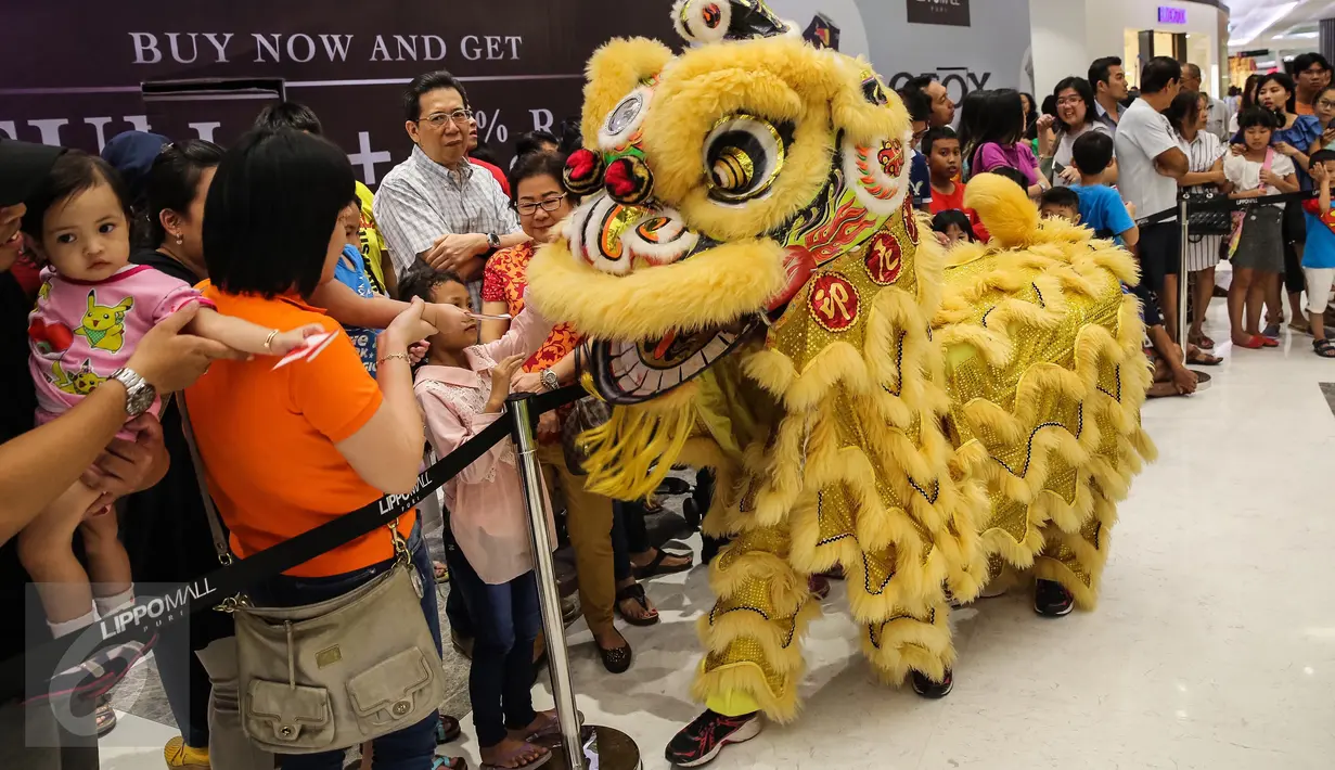 Pengunjung memberikan angpao kepada barongsai usai melakukan atraksi di Lippo Mall Puri, Jakarta Barat, (21/01). (Liputan6.com/Fery Pradolo)
