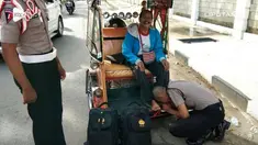 Seorang anak yang jadi polisi mencium kaki ayahnya yang merupakan seorang tukang becak bentor.