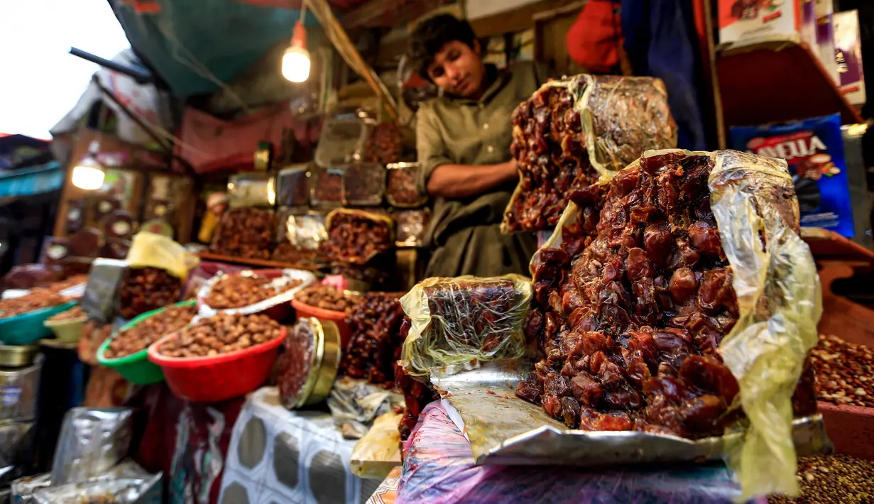 Seorang pedagang Yaman memperlihatkan kurma kering di sebuah pasar di kota tua Sanaa, Sabtu (11/5/2019). Buah kurma sangat identik saat bulan suci Ramadan, malah menjadi makanan wajib saat berbuka puasa. (Photo by Mohammed HUWAIS / AFP)