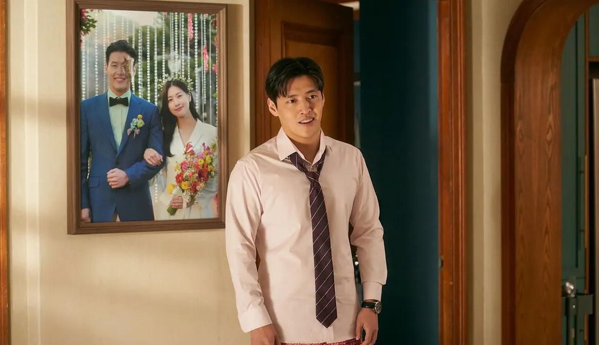 Pemirsa dapat melihat sekilas kehidupan pernikahan Jung Yeol dan Na Ra yang sulit saat mereka saling memandang dari kejauhan dengan latar belakang foto pernikahan mereka yang sebagian dirobek. (Foto: Mindmark via Soompi)