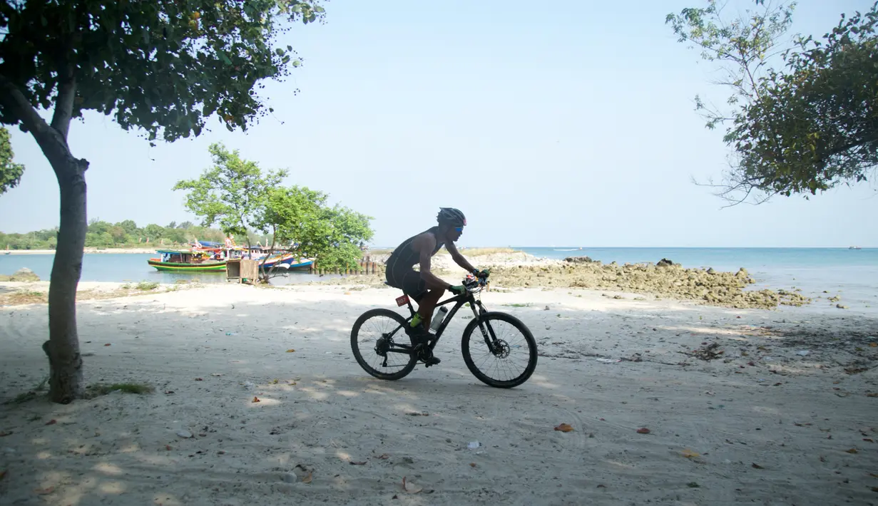 Peserta memacu sepeda ketika mengikuti Rhino Cross Triathlon 2018 di Kawasan KEK Tanjung Lesung, Pandeglang, Banten, Minggu (30/9). Rhino Cross Triathlon tersebut mempertandingkan tiga kategori lomba. (Liputan6.com/HO/Nick Hanoatubun)