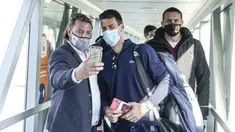 Seseorang berswafoto dengan petenis Serbia Novak Djokovic setibanya di Beograd, Senin (17/1/2022). Djokovic tiba di ibu kota Serbia setelah dideportasi Australia usai kalah dalam upaya tinggal di negara itu untuk mempertahankan gelar Australia Open meskipun tidak divaksinasi (AP Photo/Darko Bandic)