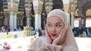 Di potret berikutnya, ia tampil dengan outfit bernuansa nude beige saat berada di area masjid. Warna ini memberi kesan bersih, lembut, dan menenangkan. Model hijab yang sederhana tanpa banyak detail justru membuat penampilannya terlihat semakin elegan. Pose kedua tangan di pipi menambahkan kesan manis namun tetap sopan, memperlihatkan sisi feminin yang hangat.  [@rklopper].