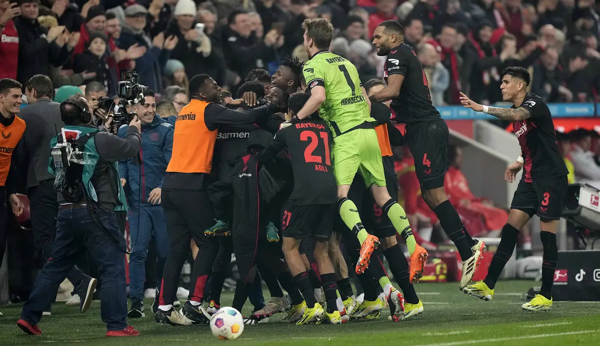 Pemain Bayer Leverkusen melakukan selebrasi setelah Jeremie Frimpong mencetak gol ketiga timnya ke gawang Bayern Munchen pada laga lanjutan Bundesliga 2023/2024 di BayArena, Leverkusen, Jerman, Minggu (11/02/2024) WIB. (AP Photo/Martin Meissner)