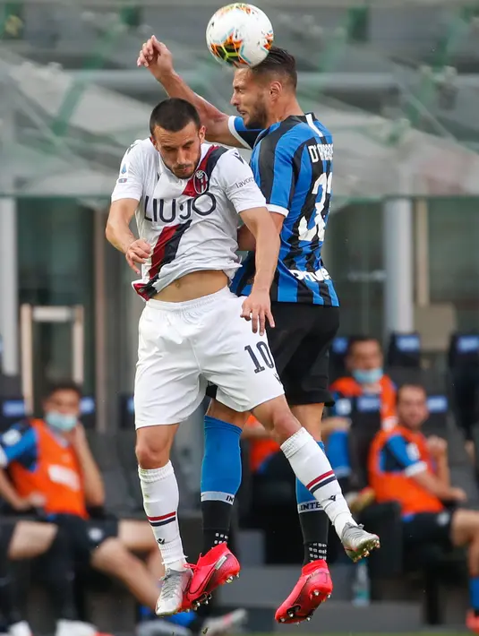 Pemain Bologna, Nicola Sansone dan pemain bek Inter Milan, Danilo D'Ambrosio melompat saat berebut bola pada pekan ke-30 Serie A 2019-2020, di Stadion Giuseppe Meazza, Minggu (5/7/2020). Inter Milan ditumbangkan Bologna 1-2 di kandang sendiri. (AP /Antonio Calanni)