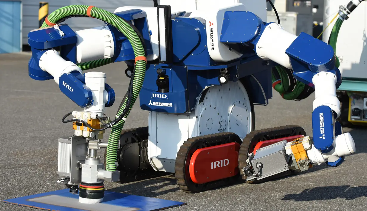 Sebuah unit robot dikendalikan dari jarak jauh untuk menghilangkan serbuk besi akibat ledakan nuklir saat demonstrasi di Chiba, Jepang (16/12). Robot dikembangkan untuk pembangkit nuklir Fukushima yang mengalami krisis sejak Tsunami. (AFP/Toru Yamanaka)
