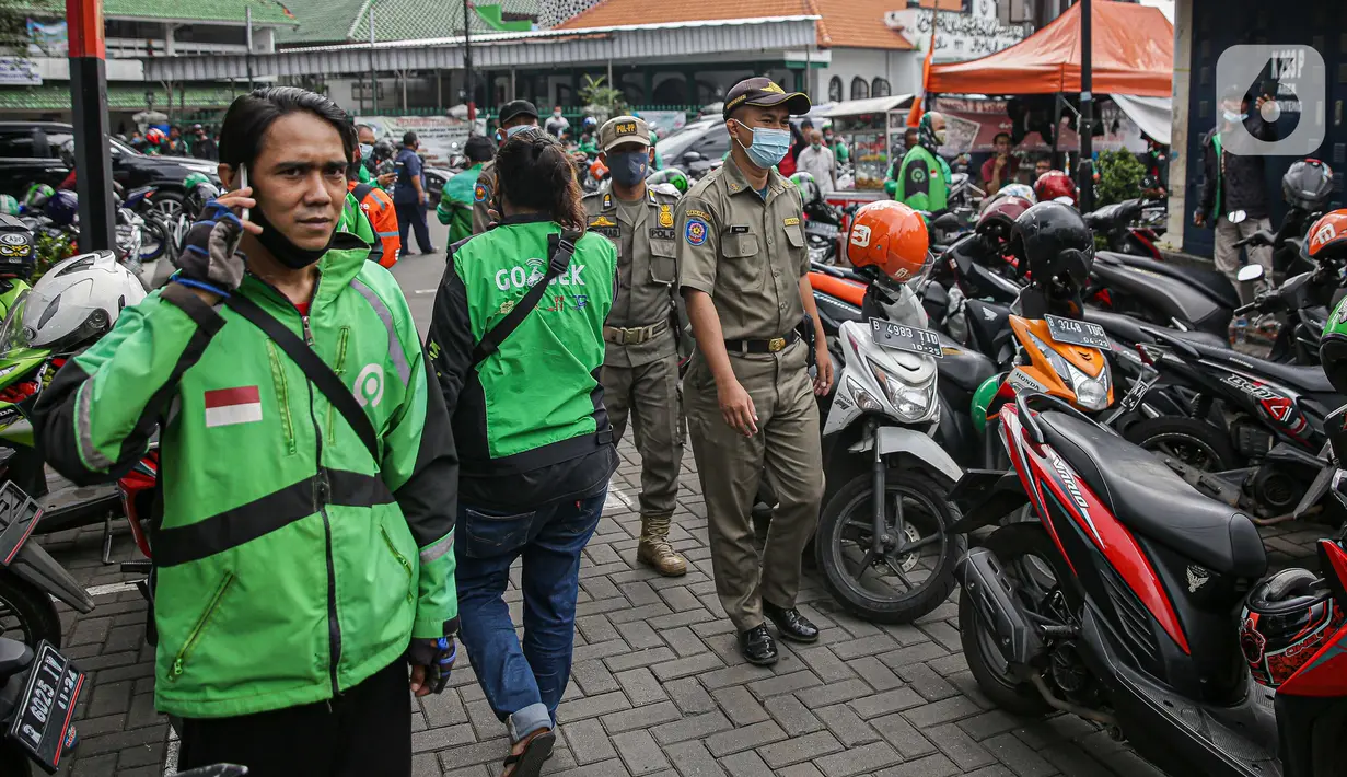 Petugas Satpol PP mendatangi gerai cepat saji McDonald's Raden Saleh, Jakarta, Rabu (9/6/2021). Puluhan driver ojek online terlihat mengabaikan protokol kesehatan saat mengantre pesanan BTS Meal yang mulai dijual. (Liputan6.com/Faizal Fanani)