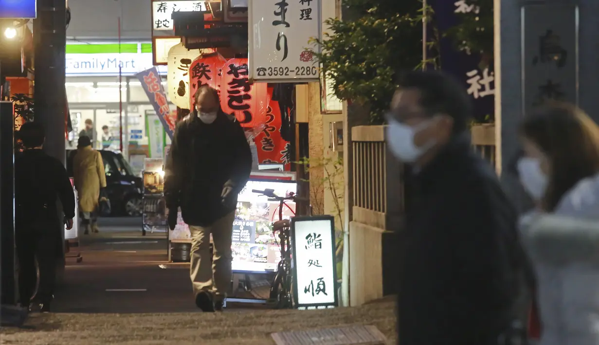 Orang-orang memakai masker untuk melindungi dari penyebaran virus corona berjalan di sepanjang jalan yang dipenuhi bar dan restoran di Tokyo, Rabu (19/1/2022). Tokyo dan puluhan daerah lain di Jepang akan menghadapi pembatasan COVID-19 baru yang berlaku efektif Jumat (21/1). (AP Photo/Koji Sasahara)