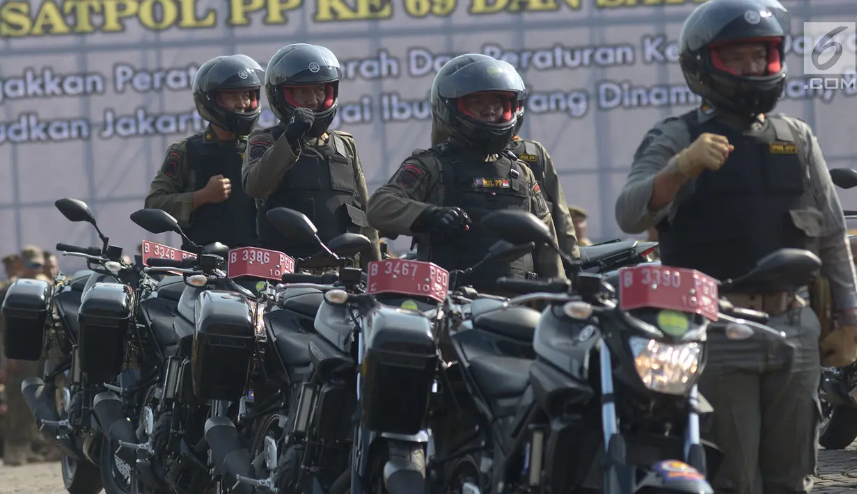 Satuan Polisi Pamong Praja (Satpol PP) mengikuti upacara peringatan HUT ke-69 Satpol PP dan ke-57 Satuan Perlindungan Masyarakat (Satlinmas) di Lapangan Monas, Jakarta, Rabu (7/8/2019). Dalam peringatan itu, Gubernur DKI Anies Baswedan bertindak menjadi inspektur upacara. (merdeka.com/Imam Buhori)