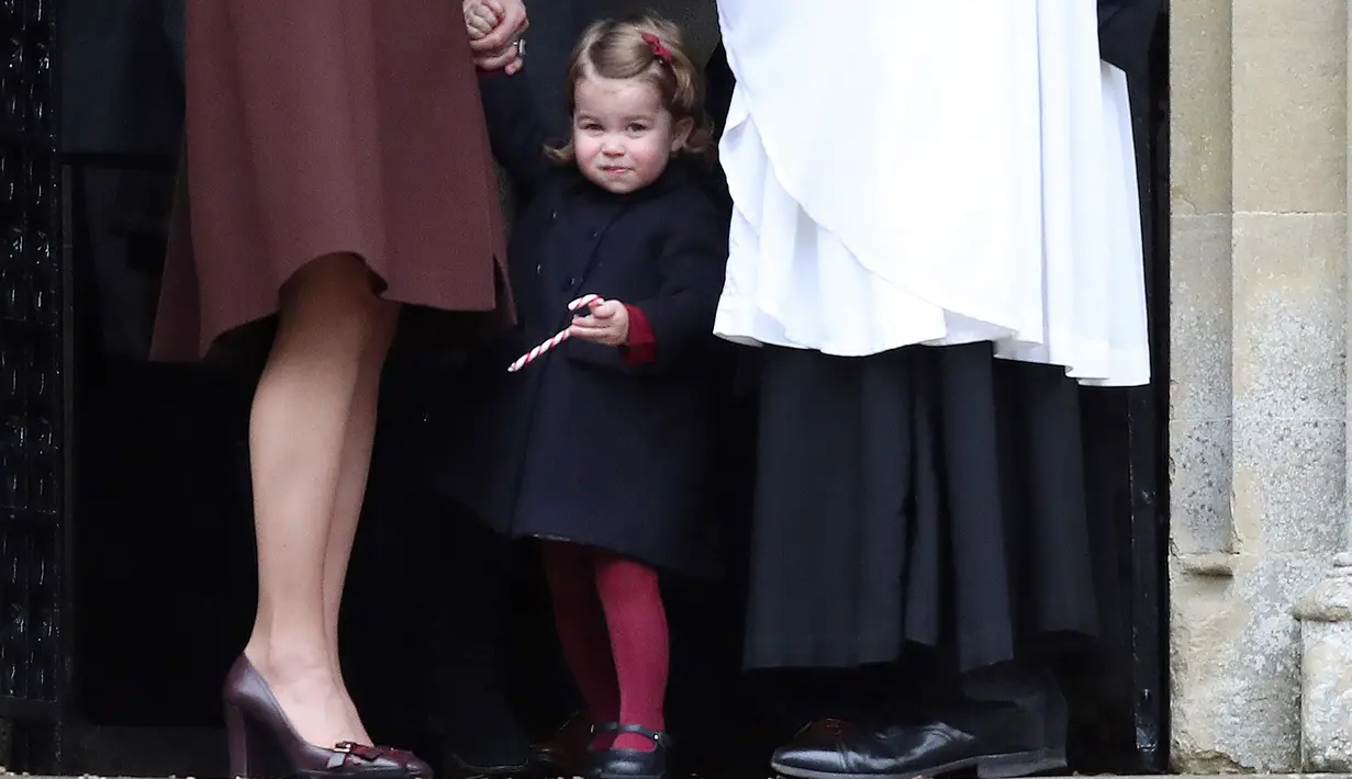 Putri Charlotte memegang permen usai mengikuti Misa Natal di Gereja St Mark, Englefield, Inggris, Minggu (25/12). Pangeran William dan Kate Middleton mengajak kedua anaknya merasakan Natal di kawasan tempat tinggal ibu Kate. (REUTERS/Andrew Matthews/Pool)