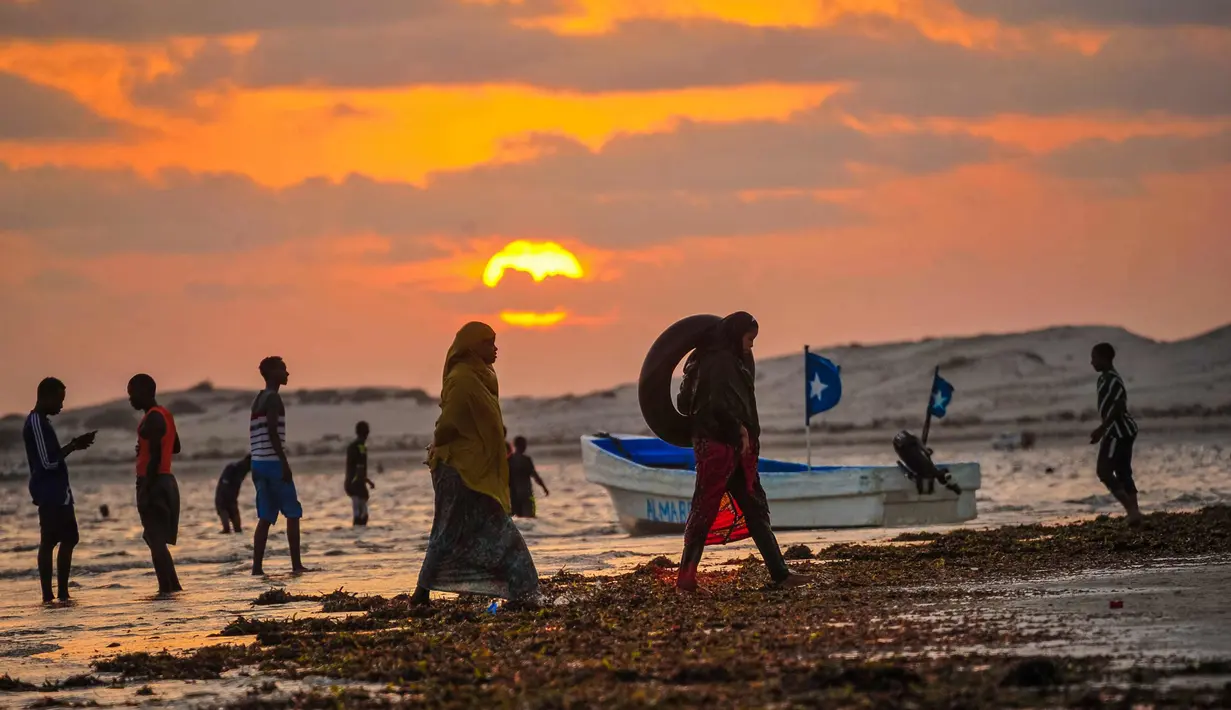 Sejumlah warga berkumpul saat matahari terbenam di Pantai Jazera di pinggiran Mogadishu, Somalia (24/11). Pantai ini jadi tempat rekreasi populer bagi warga Somalia. (AFP Photo/Mohamed Abdiwahab)