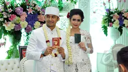 Hengky Kurniawan dan Sonya Fatmala menunjukan buku nikah seusai prosesi akad nikah di sebuah hotel kawasan TMII, Jakarta, Kamis (23/4/2015). (Liputan6.com/Panji Diksana)