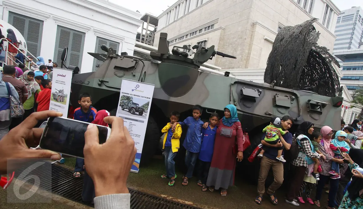 Warga berfoto disamping Panser Anoa dalam Habibie Festival di Museum Nasional, Jakarta, Minggu (14/8).Dalam Habibie Festival kali ini warga dapat melihat langsung Pesawat N250 dan Panser Anoa buatan anak bangsa tersebut. (Liputan6.com/Immanuel Antonius)