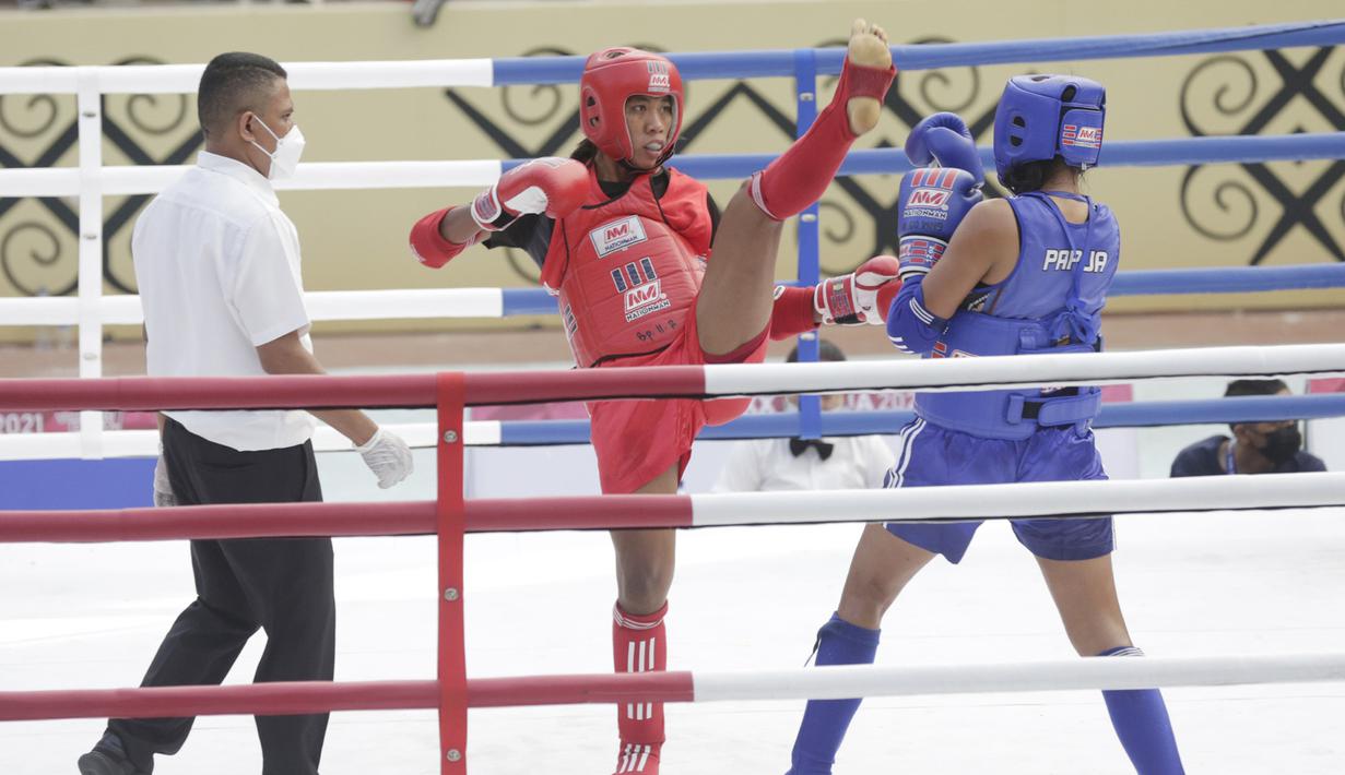 Atlet Muaythai NTT, Susanti Ndapataka (merah) bertarung dengan atlet Muaythai Papua, Iriani Labagai (biru) saat babak penyisihan Muaythai kelas 70 kg putri di GOR STT Gidi, Sentani, Papua, Rabu (29/9/2021). (FOTO : PBPON XX PAPUA/Dhoni Setiawan)