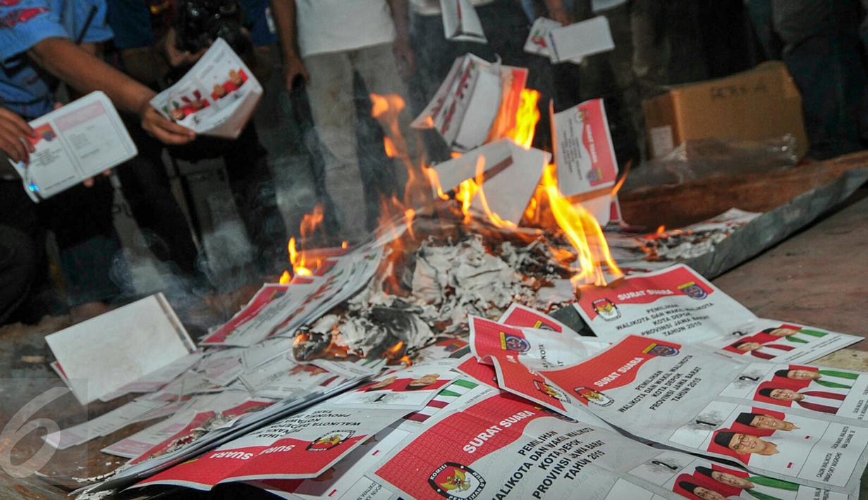 Anggota KPU Depok memusnahkan ratusan suara rusak dan kelebihan di Gudang Logistik KPU Depok, Selasa (8/12). Sebanyak 1576 surat suara yang terdiri dari 398 rusak dan 1178 kelebihan tersebut di musnahkan dengan cara dibakar. (Liputan6.com/Yoppy Renato)
