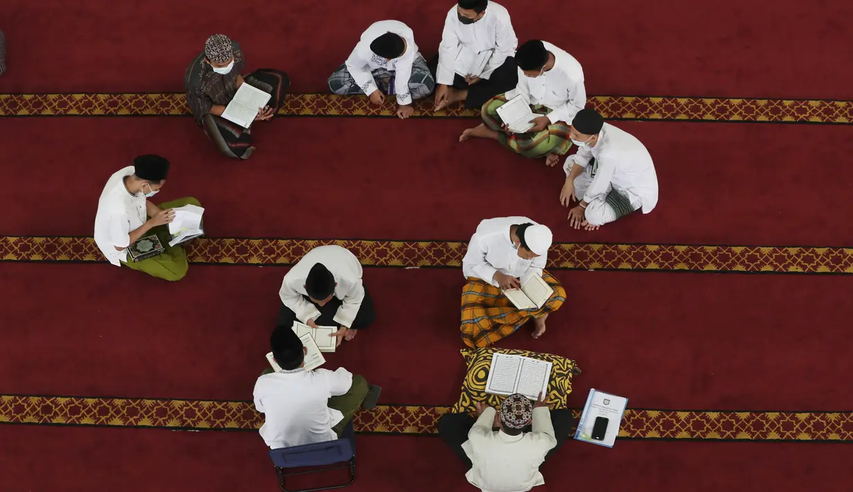 Para siswa mengenakan masker untuk membantu mengekang penyebaran COVID-19 saat membaca kitab suci Alquran di Masjid Attaqwa, Bekasi, Jawa Barat, Selasa (4/5/2021). Selama Ramadhan, umat muslim menahan diri dari makan, minum, merokok dan seks dari subuh hingga maghrib. (AP Photo/Achmad Ibrahim)