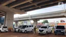 Warga berjalan dekat mobil yang parkir di kolong jalan tol Becakayu di kawasan Cipinang Muara, Jakarta, Jumat (13/3/2020). Minimnya lahan parkir membuat sebagian orang tetap memarkirkan kendaraannya di kolong tol tersebut, meskipun telah terpampang larangan parkir. (Liputan6.com/Immanuel Antonius)