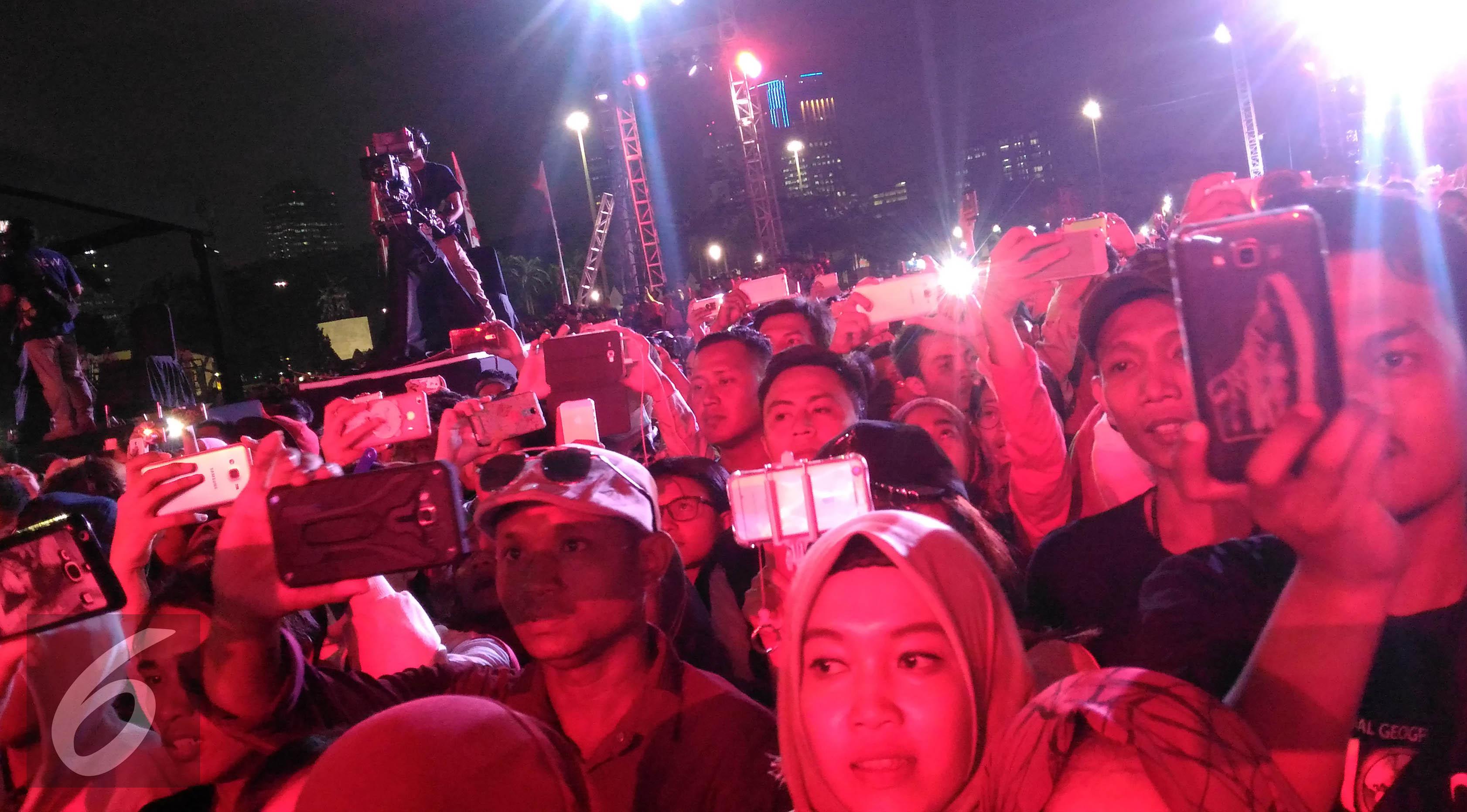Masyarakat antusias menunggu penampilan SNSD di ajang Countdown Asian Games 2018 di Lapangan Monumen Nasional (Monas), Jumat (18/8/2017) malam. (Zulfa Ayu Sundari/Liputan6.com)