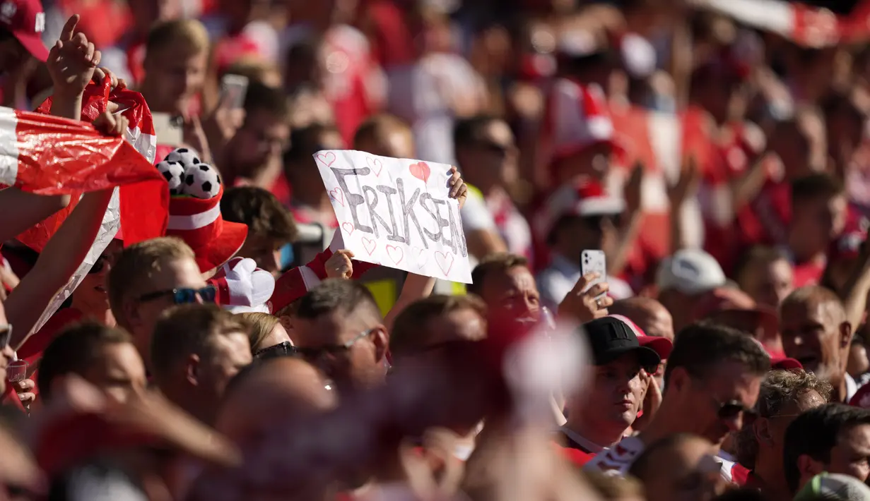 Seorang penonton memegang poster bertuliskan nama bintang timnas Denmark, Christian Eriksen menjelang laga grup B Euro 2020 di stadion Parken, Kamis (17/6/2021). Duel Denmark vs Belgia berhenti sejenak pada menit ke-10 untuk memberi penghormatan kepada Eriksen. AP Photo/Martin Meissner, Pool)