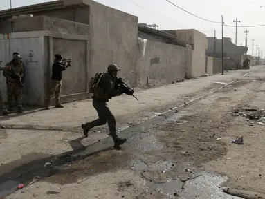 Suasana kontak senjata antara pasukan Irak dan militan ISIS di wilayah Mosul, Irak (10/1). Pertempuran dengan militan ISIS kembali terjadi saat pasukan Irak sedang melakukan evakuasi warga Mosul. (AP Photo/Khalid Mohammed)