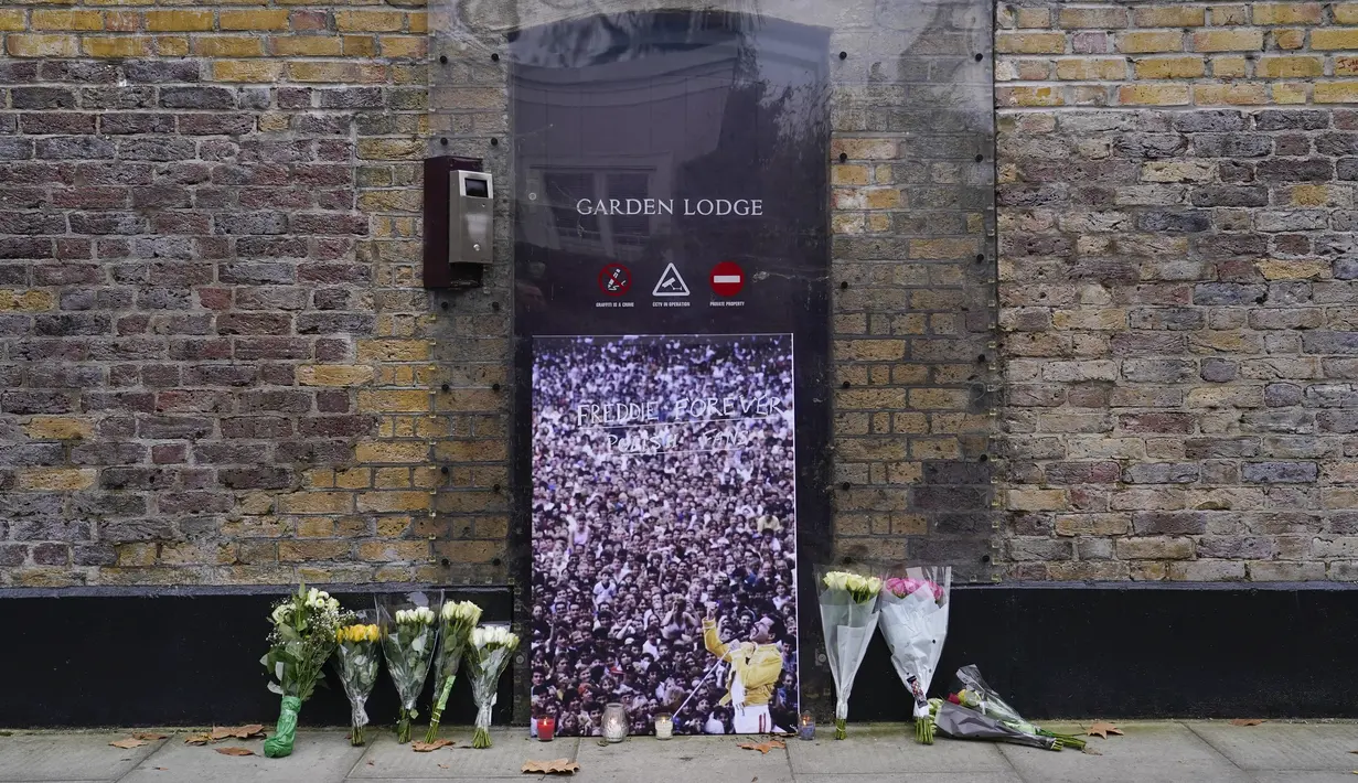 Bunga, lilin, gambar dan bendera dengan pesan ditinggalkan di luar rumah mendiang Freddie Mercury, pada peringatan 30 tahun kematiannya, di London, Rabu (24/11/2021). Freddie Mercury, penyanyi yang juga pentolan grup band Queen  meninggal dunia pada 24 November 1991. (AP Photo/Alberto Pezzali)