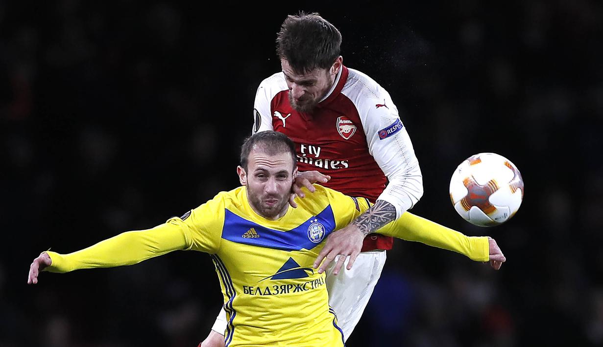 Bek Arsenal, Mathieu Debuchy, duel udara dengan gelandang BATE Borisov, Igor Stasevich, pada laga Liga Europa di Stadion Emirates, Jumat (8/12/2017). Arsenal menang 6-0 atas BATE Borisov. (AP/Kirsty Wigglesworth)