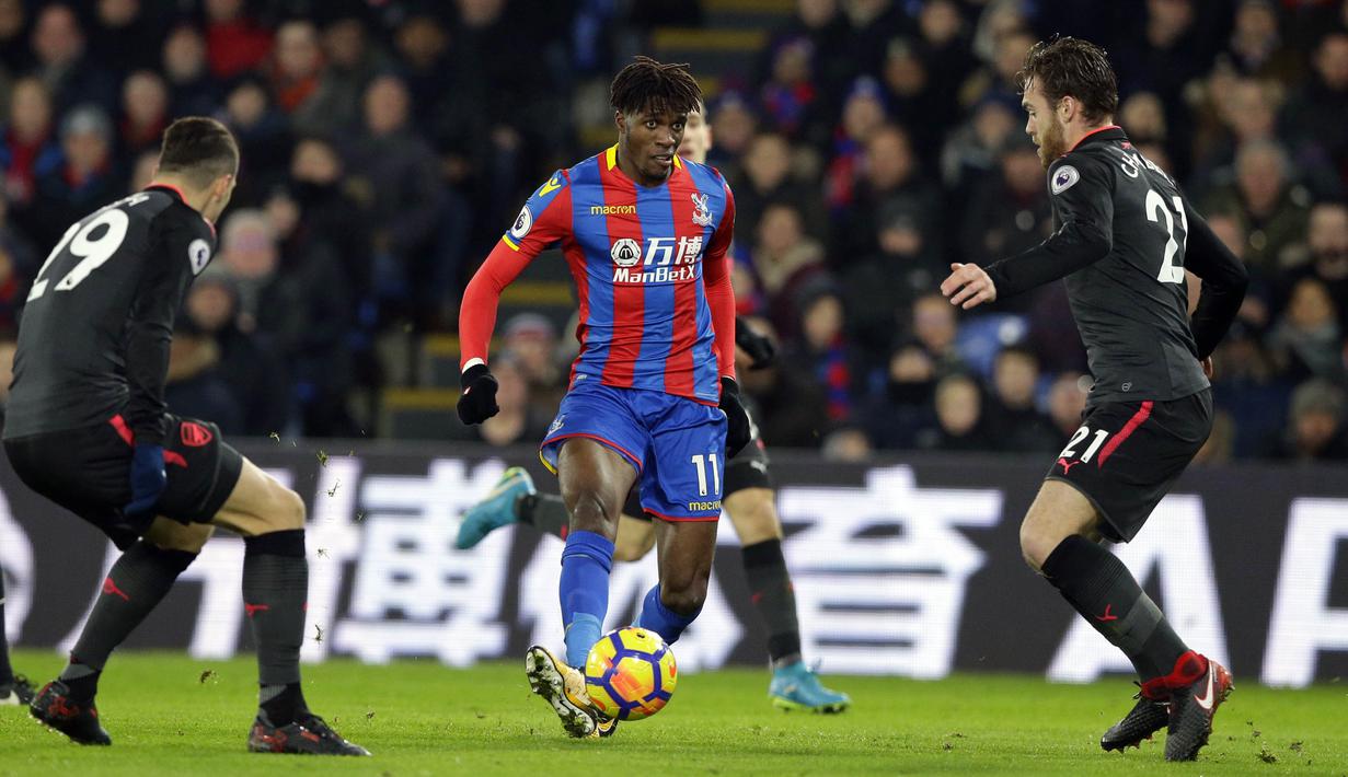 Gelandang Crystal Palace, Wilfried Zaha, berusaha melewati pemain Arsenal pada laga Premier League di Stadion Selhurst Park, Jumat (29/12/2017). Arsenal menang 3-2 atas Crystal Palace. (AP/Alastair Grant)