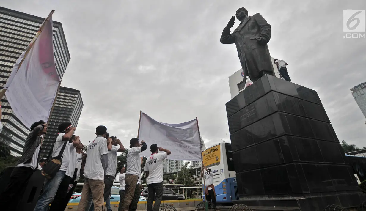 Sejumlah aktivis melakukan penghormatan sambil mengheningkan cipta di depan patung Jenderal Soedirman, Jakarta, Rabu (14/11). Aksi ini dalam rangka memperingati Hari Pahlawan dan menghormati jasa-jasa Jenderal Soedirman. (Merdeka.com/ Iqbal S. Nugroho)