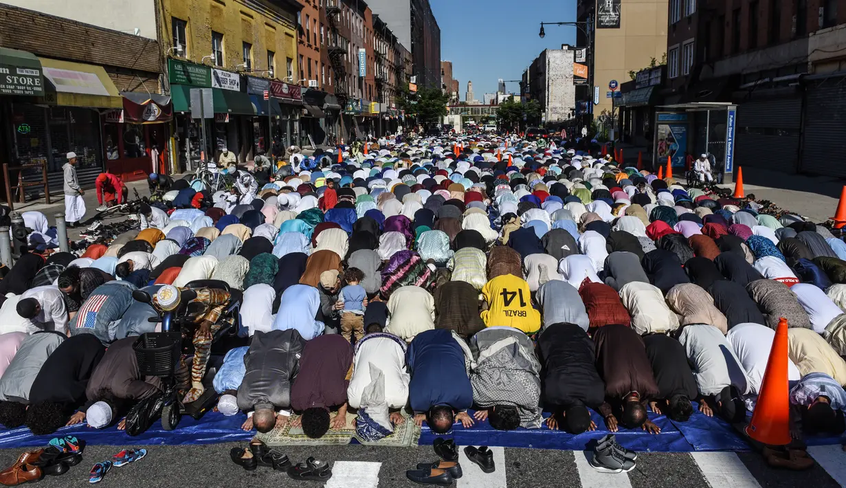 Umat muslim melaksanakan salat Idul Fitri di luar Masjid at-Taqwa, Brooklyn, New York City, Amerika Serikat, Selasa (4/6/2019). Ribuan umat muslim melaksanakan salat Idul Fitri di jalanan New York City. (Stephanie Keith/Getty Images North America/AFP)