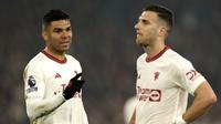 Pemain Manchester United, Casemiro, berbincang dengan Diogo Dalot saat melawan Crystal Palace dalam laga pekan ke-36 Premier League 2023/2024 yang digelar di Selhurst Park, Selasa (7/5/2024). (AP Photo/Ian Walton)