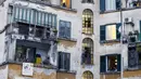 Orang-orang bermain panci selama flash mob di seluruh Italia untuk menyatukan orang-orang dan mencoba mengatasi keadaan darurat  virus corona Covid-19 di lingkungan Garbatella, di Roma, Jumat (13/3/2020). (Cecilia Fabiano/LaPresse via AP)