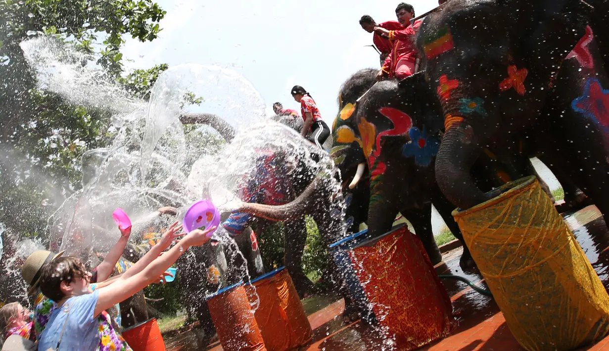 Sejumlah wisatawan asing bermain air bersama gajah saat perayaan tahun baru kuno Thailand atau Songkran di provinsi Ayutthaya, Thailand (11/4). Songkran sudah menjadi festival dan event wisata di Thailand. (AP Photo/Sakchai Lalit)