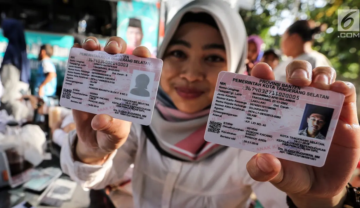 Petugas Disdukcapil menunjukkan dua Kartu Identitas Anak (KIA) untuk balita dan anak di atas lima tahun di Pondok Aren, Tangerang Selatan, Jumat (16/11). Pemkot menargetkan 2019 mendatang layanan penerbitan KIA sudah rampung. (Liputan6.com/Fery Pradolo)