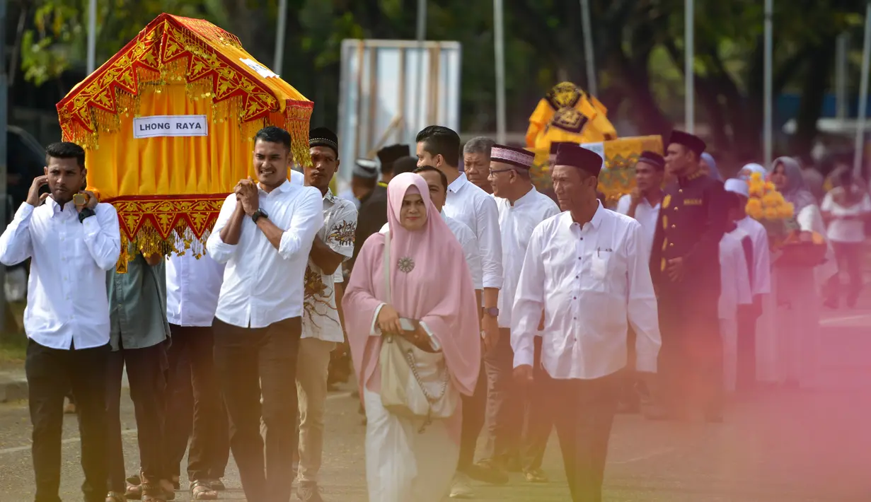 Warga membawa hidangan menu makanan selama perayaan maulid akbar Nabi Muhammad SAW di Banda Aceh, Aceh, Kamis (6/2/2020). Acara maulid akbar tersebut menyediakan 808 hidangan dari 90 desa dan instansi pemerintah dengan mengundang 25.000 tamu dari berbagai daerah. (Photo by Chaideer MAHYUDDIN / AFP)